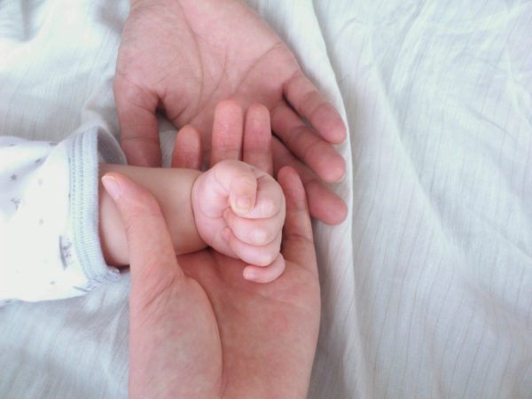 赤ちゃんと両親の手