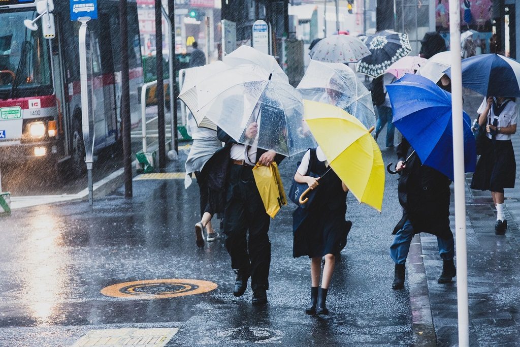大雨の中傘をさす人々
